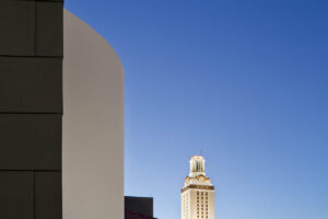 a large building with the sky and UT tower in the distance