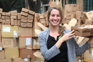 A photo of Brianna Duran surrounded by boxes to be recycled.