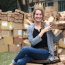 A photo of Brianna Duran surrounded by boxes to be recycled.