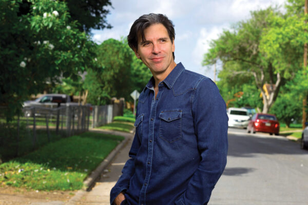 Oscar Cásares stands in a residential street.