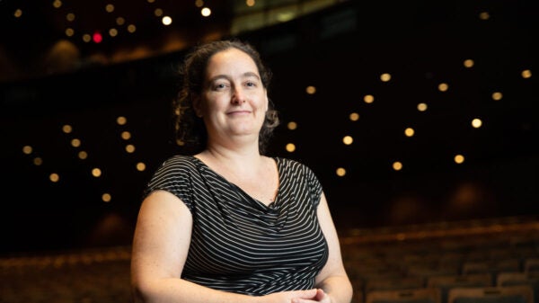 A woman stands in an empty theater.