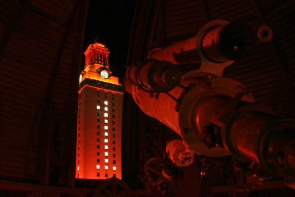 A photo of the Painter telescope and the UT Tower at night.