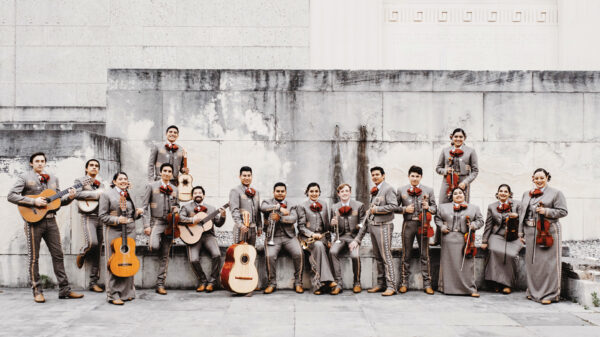 Group photo of mariachi band standing in uniform with their instruments