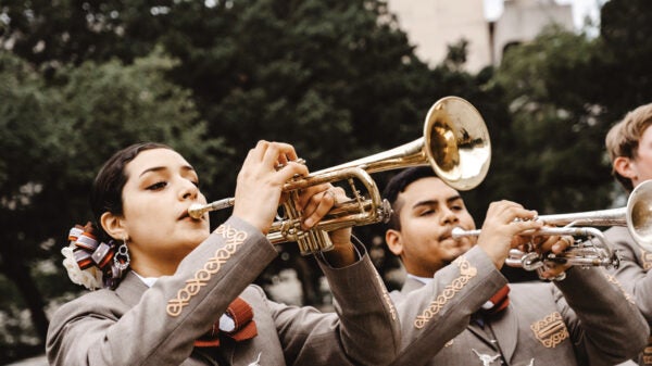 Two mariachi band members play trumpets.