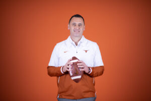 Portrait of Steve Sarkisian standing with a football in his hands