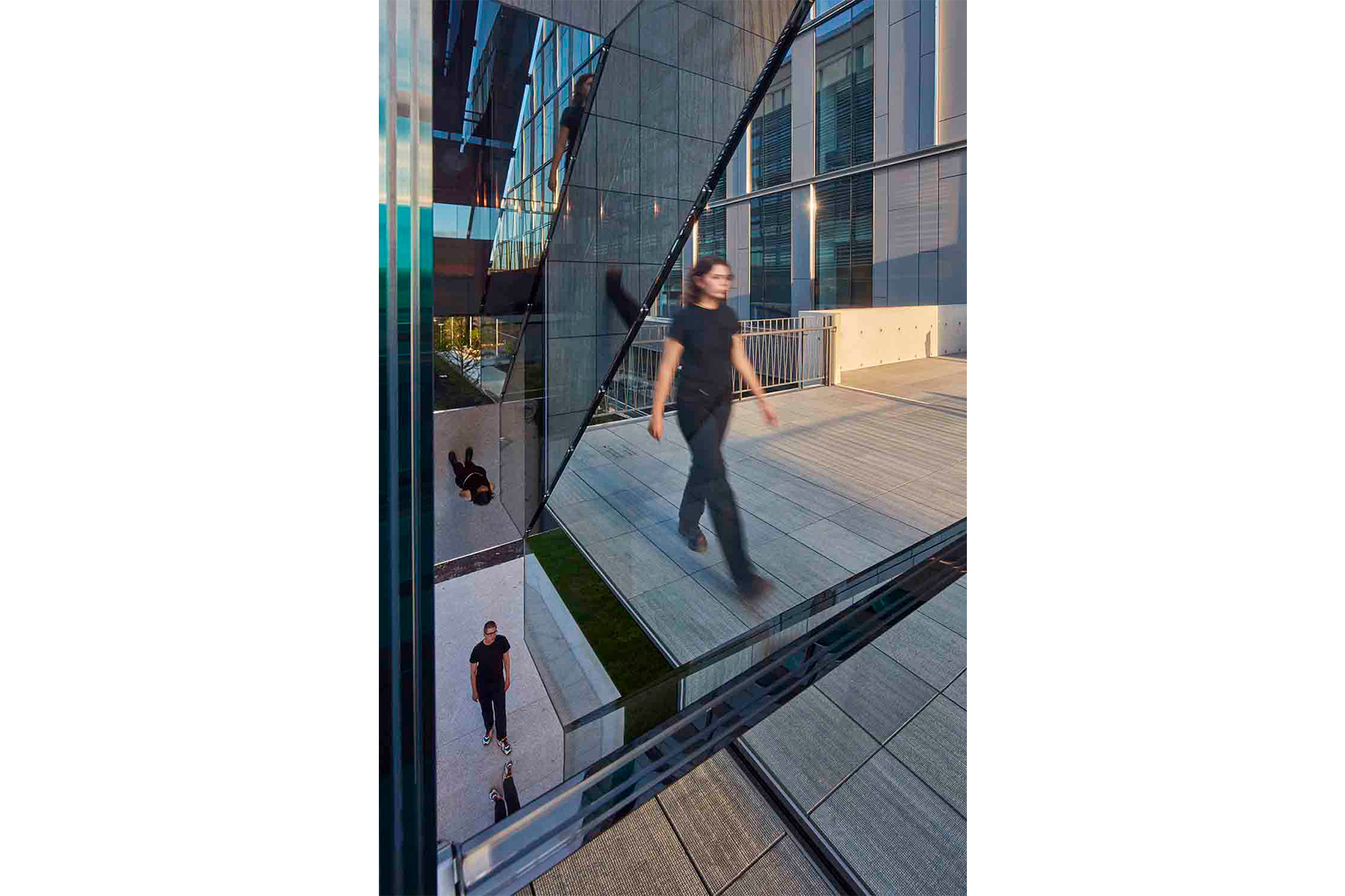 Sculpture made of glass panes with person walking past