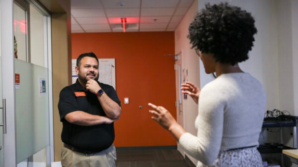 Javier Garcia speaks with someone in the office