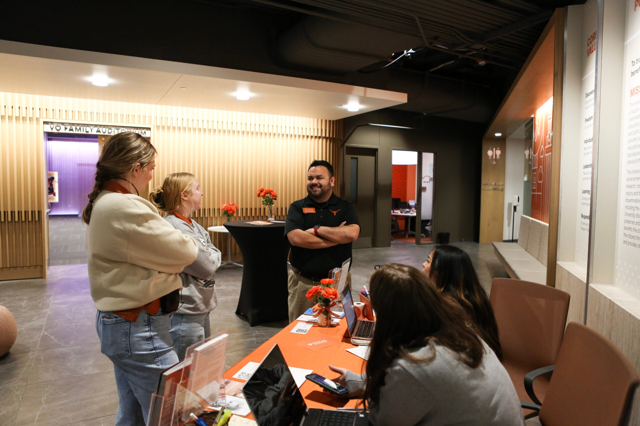 Javier Garcia smiles and talks with people at the Admissions Welcome Center