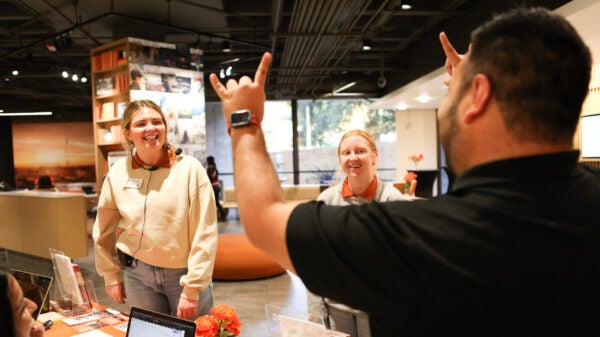 Javier Garcia does the Hook 'em Horns hand sign to tour guides