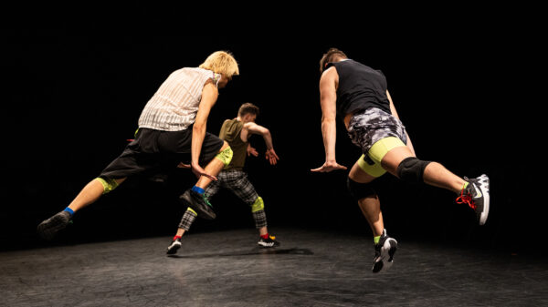 Three people dancing dynamically on a stage