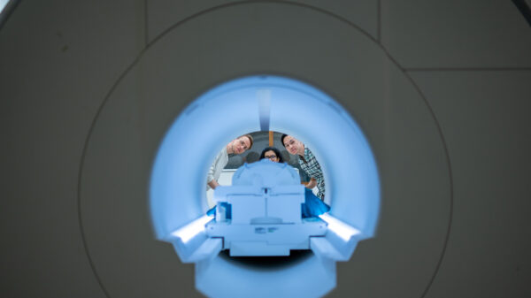 Three researchers seen at the other end of an MRI machine