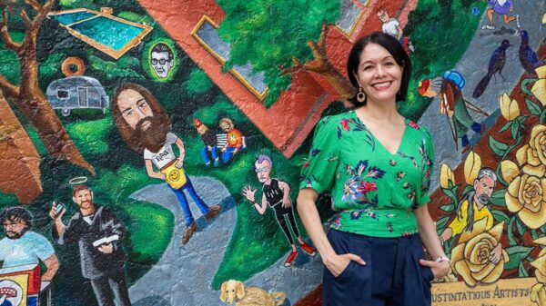 Woman stands in front of a mural