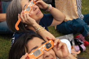 People view the 2024 Total Eclipse while wearing eclipse glasses