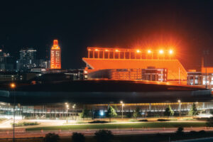 UT Tower with SEC lit up on its windows and Darrell K Royal-Texas Memorial Stadium in the foreground