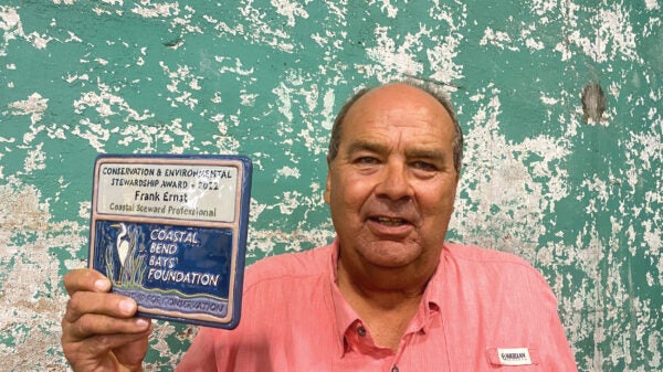 Portrait of a man holding up a plaque